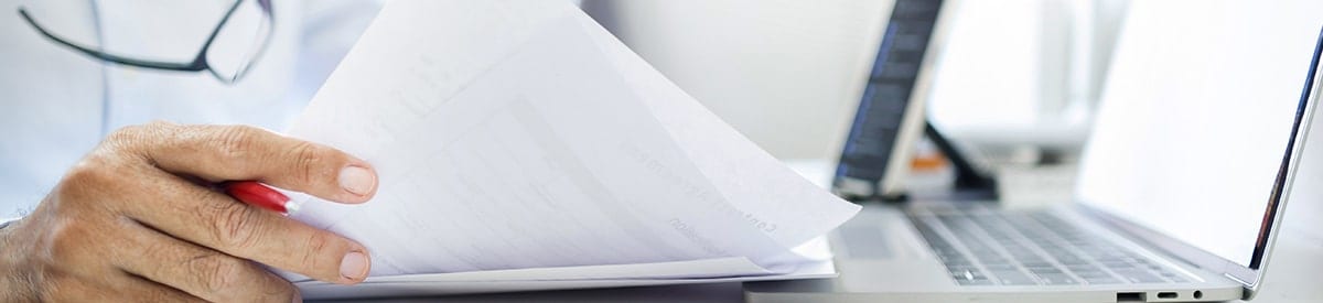 primo piano della mano di una persona che tiene una pila di documenti